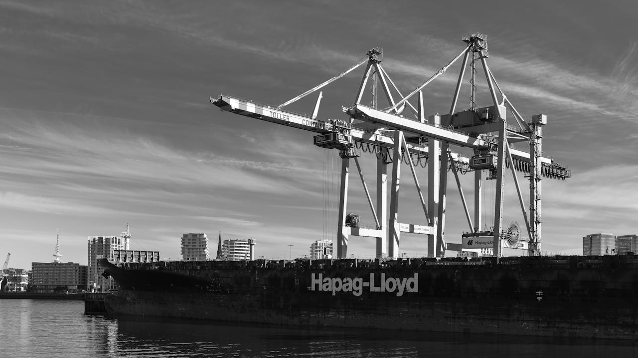 Black and white image of cranes and a container ship at Hamburg port.